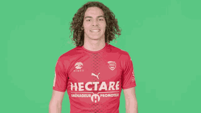 a man wearing a red shirt that says hectare