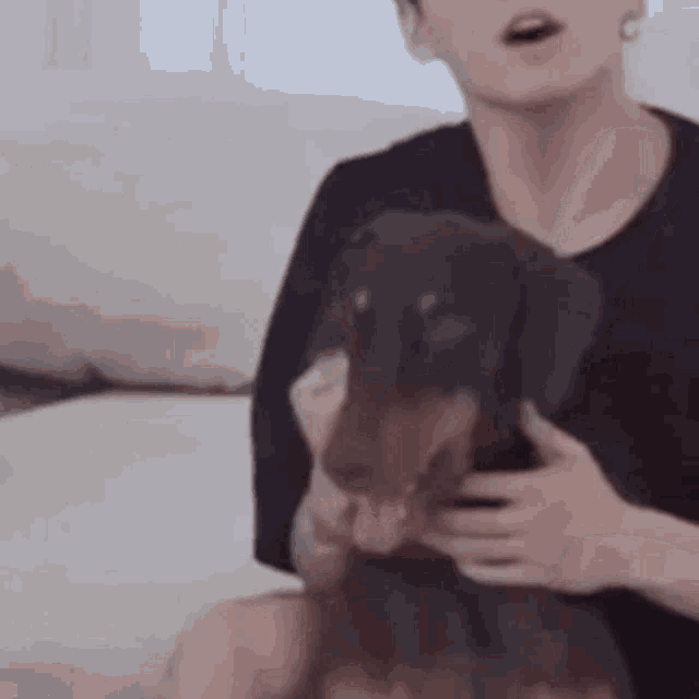 a man is sitting on a couch holding a dog .