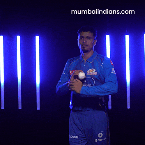 a man in a blue shirt is throwing a ball in front of a mumbaiindians.com logo