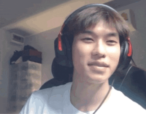a man wearing headphones looks at the camera and smiles