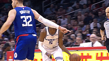 a basketball player with the number 32 on his jersey is pointing at another player