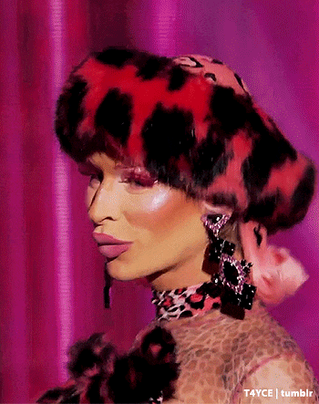 a close up of a woman wearing a leopard print hat and earrings