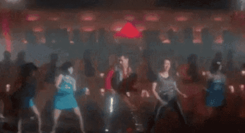 a group of people are dancing together in a club .
