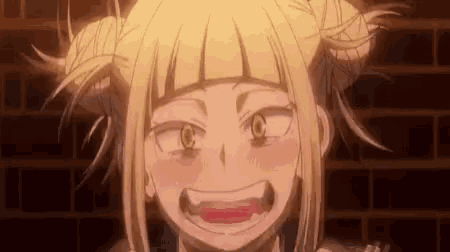 a close up of a girl with blonde hair and pigtails making a funny face in front of a brick wall .