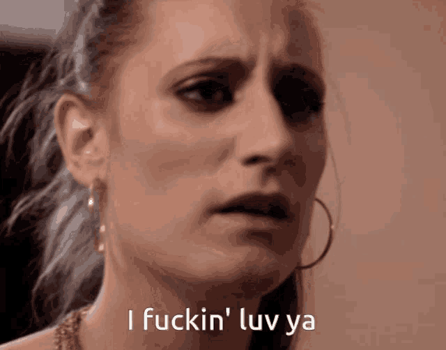 a close up of a woman 's face with the words i fuckin ' luv ya above her