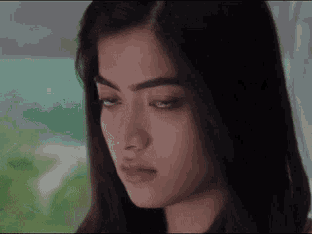 a close up of a woman 's face with a serious look on her face