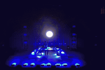 a man is playing a keyboard on a stage with the words say behind him