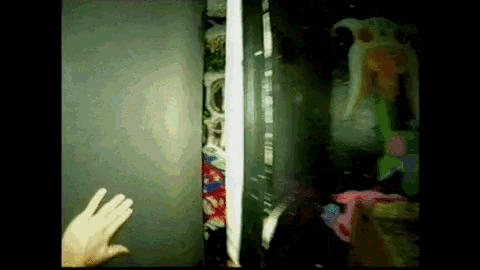 a person 's hand is reaching out from behind a door