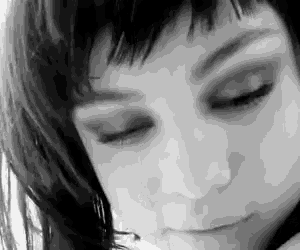 a woman 's face is shown in a black and white photo with her eyes closed
