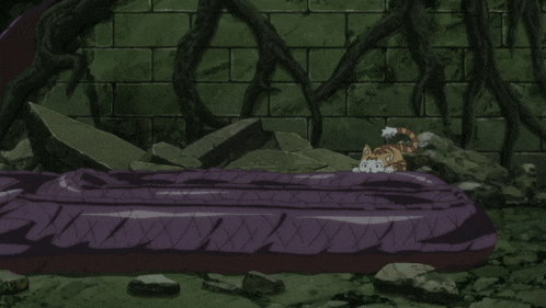 a cat laying on a purple blanket in front of a stone wall