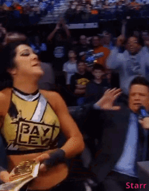 a woman in a yellow top that says bayley