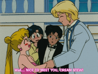a man in a tuxedo talks to a woman in a pink dress