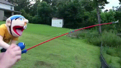 a stuffed animal is holding a fishing rod in a field .