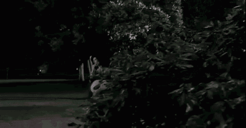 a pregnant woman in a bikini is walking in a dark park at night .