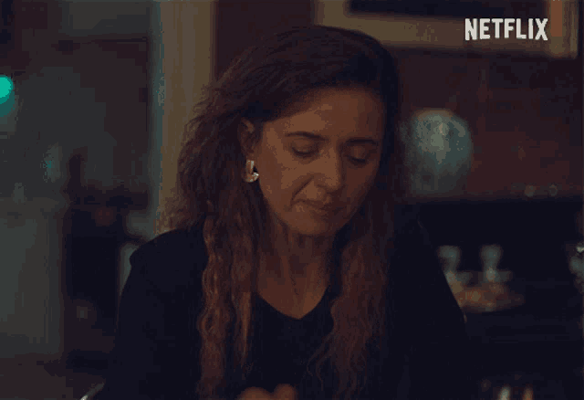 a woman is eating something with a netflix logo in the corner