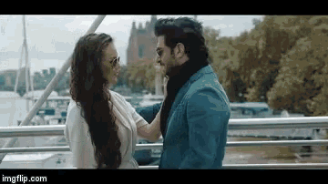 a man and woman are standing next to each other on a bridge .