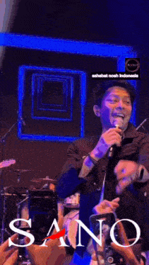 a man singing into a microphone in front of a crowd with sano written on the bottom