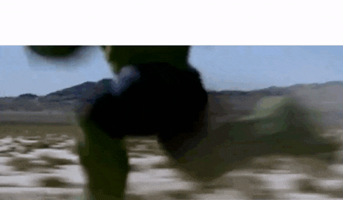 the hulk is running in the desert in a blurry photo .