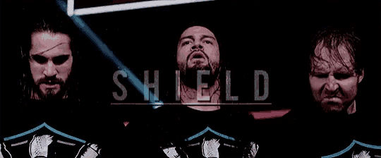 three men are standing next to each other in a dark room with the word shield behind them .