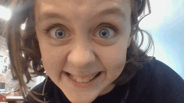 a close up of a young girl 's face with a surprised look on her face
