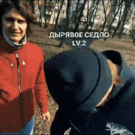 a man in a red jacket talks to another man in a black hat in a park