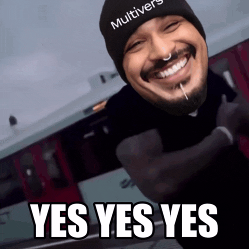 a man wearing a black multiverse beanie is smiling
