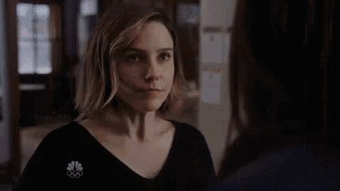 a woman is talking to another woman in a room while looking at the camera .