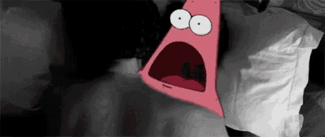 patrick star from spongebob squarepants is screaming in a bed .