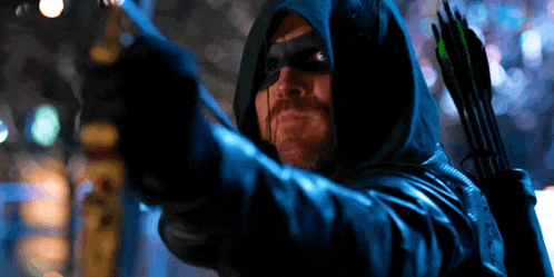 a man in a hooded jacket is holding an arrow