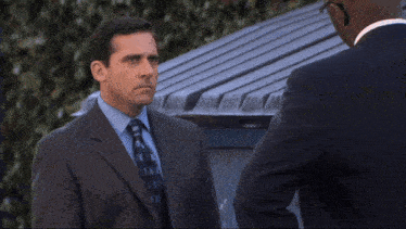 a man in a suit and tie is talking to another man with the word understand written below him