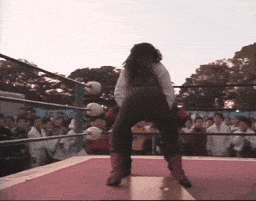 a woman in boxing gloves is standing on a red mat