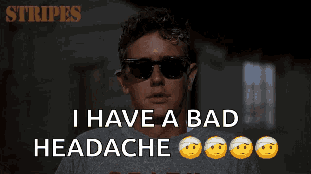 a man wearing sunglasses holds his hand to his forehead and says " i have a bad headache "