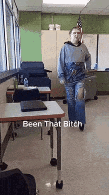 a person standing in a classroom with the words been that bitch written on the floor