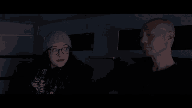 a man and a woman are talking in the dark