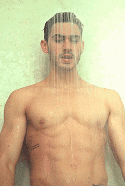 a shirtless man taking a shower with a tattoo on his chest that says " i love you "