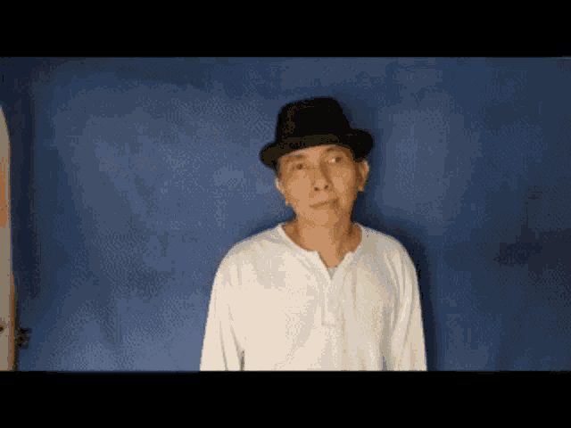 a man wearing a black hat and a white shirt