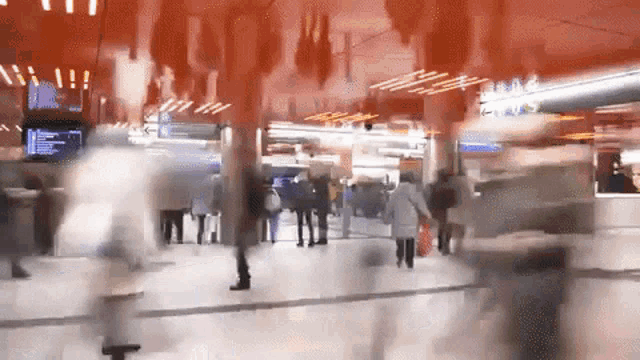 a blurry picture of a crowd of people walking in a building