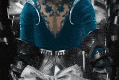 a woman in a blue dress is sitting in a chair