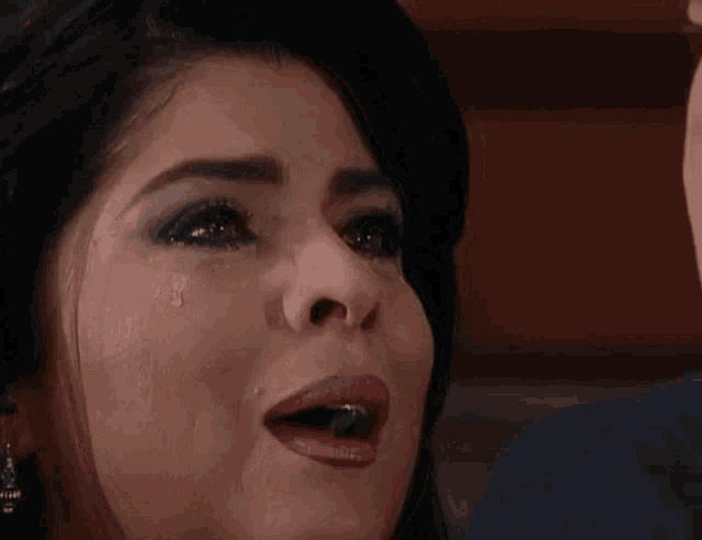 a close up of a woman 's face with tears running down her face