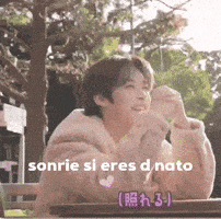 a man is sitting at a table with a sign that says sonrie si eres d.nato .