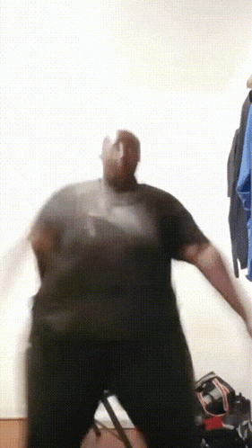 a man in a black shirt is dancing with his arms outstretched