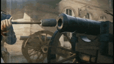 a man is holding a cannon in front of a building in a video game
