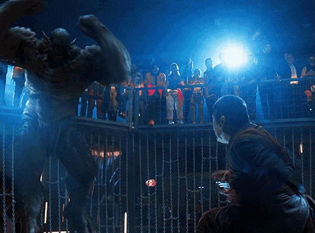 a group of people are watching a statue of a monster