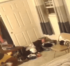 a room with a lot of clothes on the floor and a chair in it .