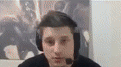 a man wearing headphones and a microphone is sitting in front of a painting on a wall .
