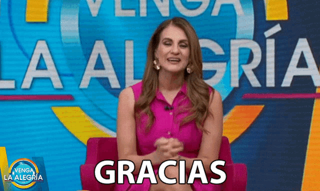 a woman is sitting in front of a sign that says la alegria