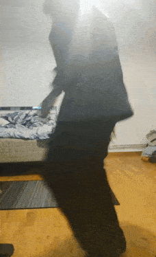 a blurry picture of a person dancing in a bedroom with a bed in the background