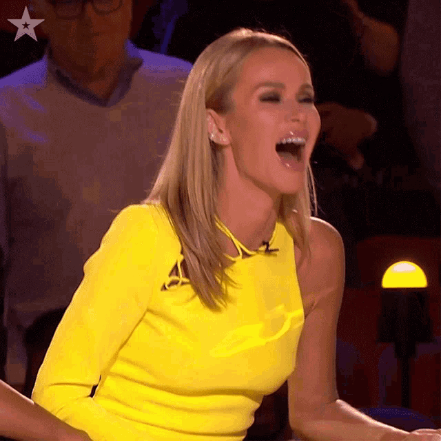 a woman in a yellow dress is laughing with a star on her chest