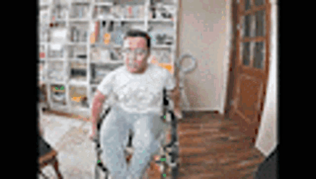 a man in a wheelchair is standing in a living room .