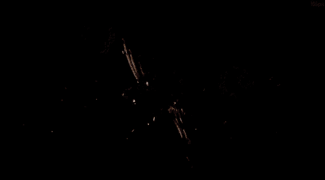 a person is holding a gun in a dark room and shooting bullets .